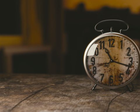 selective focus photography gray analog clock on black surface