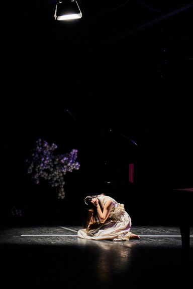 Women kneeling on dark stage