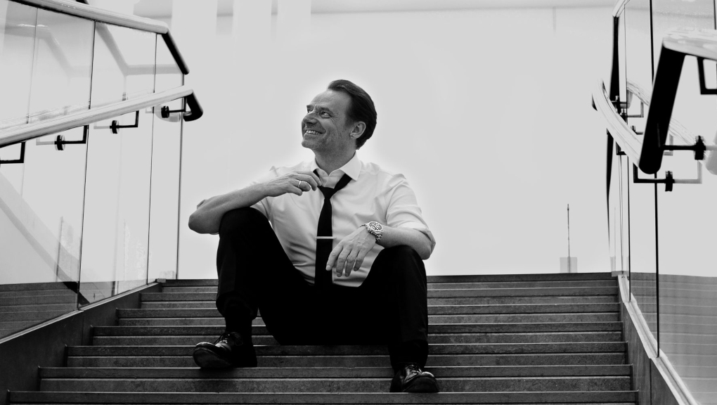 Man sitting on backlit stairs