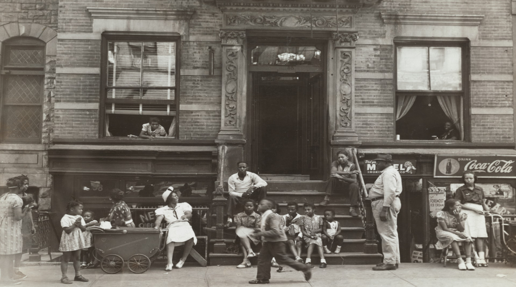 People sitting in front of tenement building