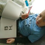 Boy drawing in hospital bed