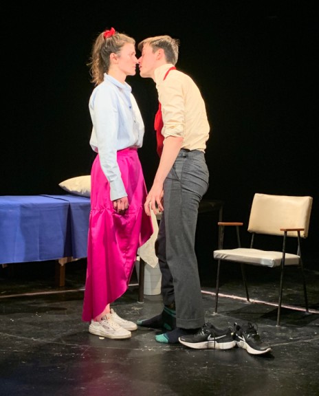 Man and woman kissing on stage