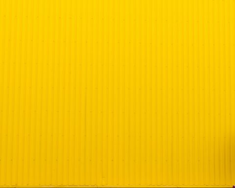 Woman walking against yellow background