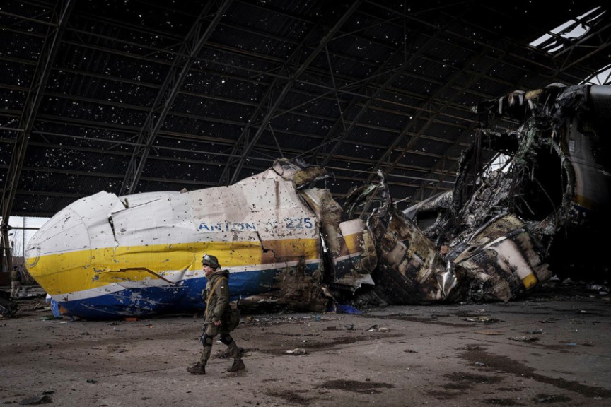 Soldier in front of burnt airplane