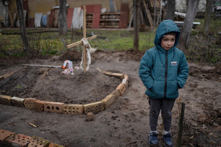 Boy next to mother's grave