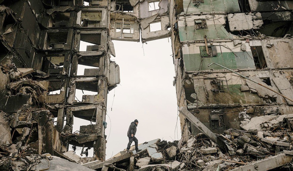 Man in front of shelled building