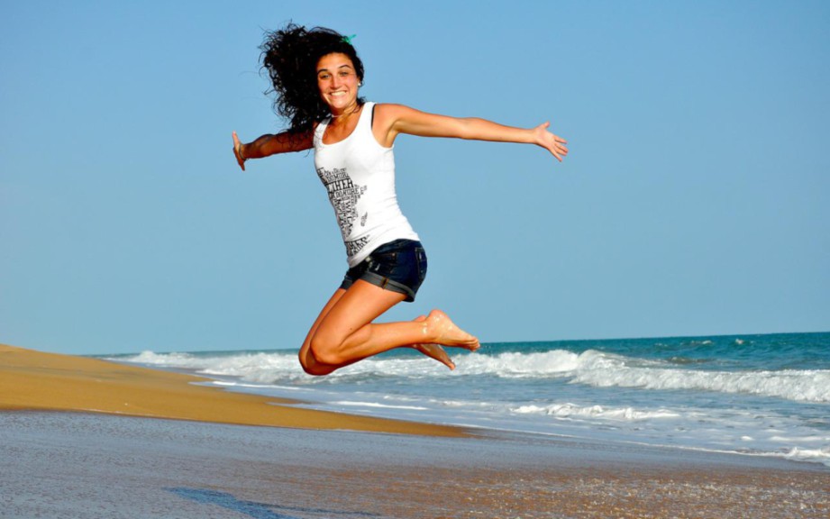 woman leaping on beach