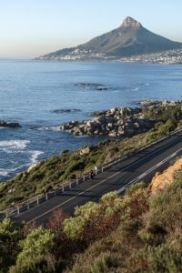 man cycling along coastal road