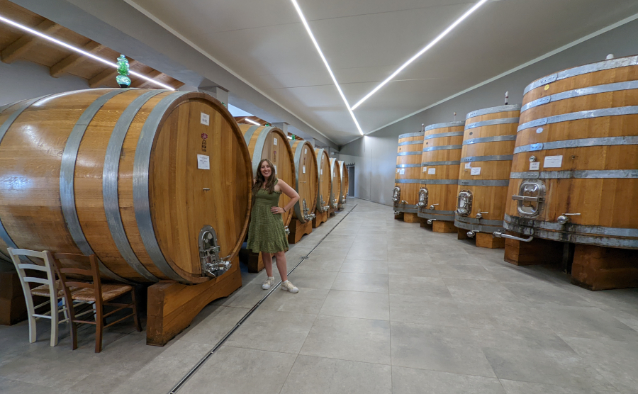 Woman posing with wine barrels