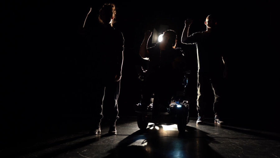 Three dancers backlit on stage