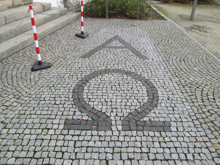 Greek letters alpha and omega on cobblestones