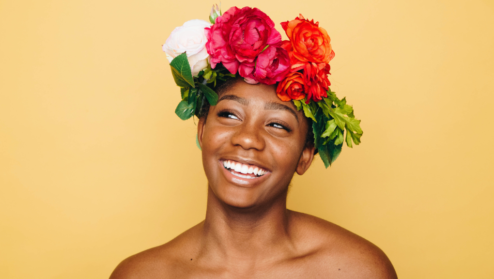 African woman smiling with flower garland