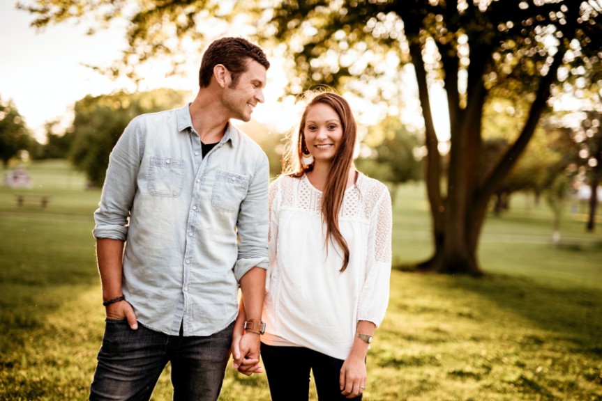 Couple facing camera, standing in park