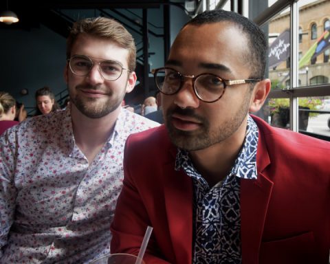 Interracial couple, two men facing camera in restaurant