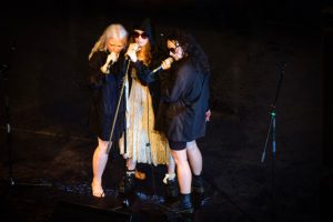 Three female performers on stage