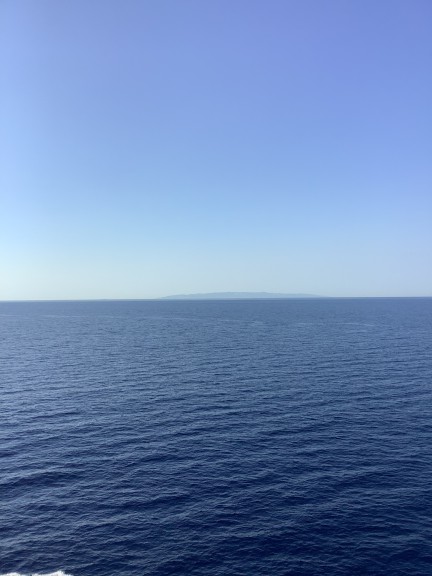 View of distant island across the sea
