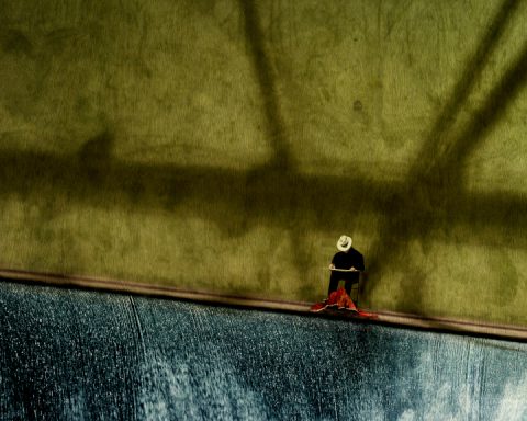 Artistic photo of man seated against wall