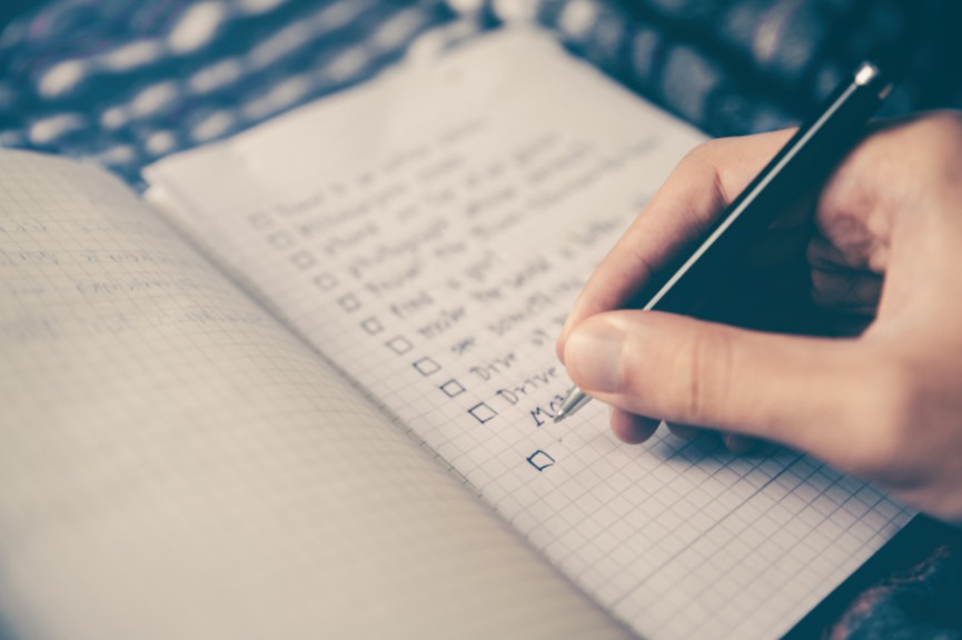 Close up of person's hand writing in journal