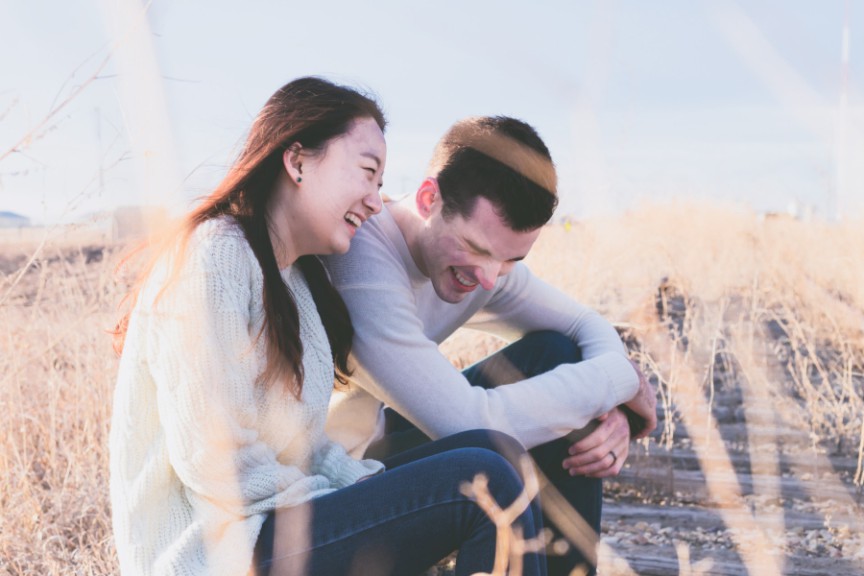 Couple seated outside laughing