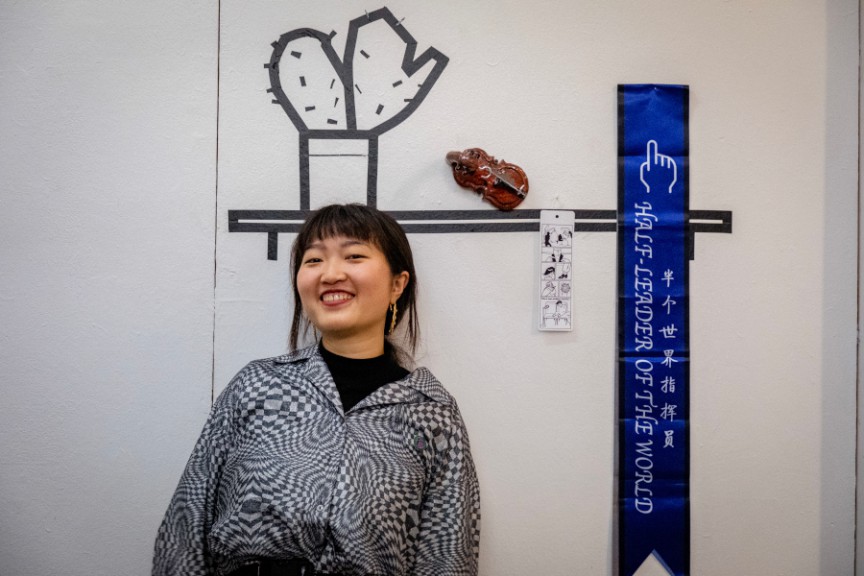 Chinese female artist standing in front of her work