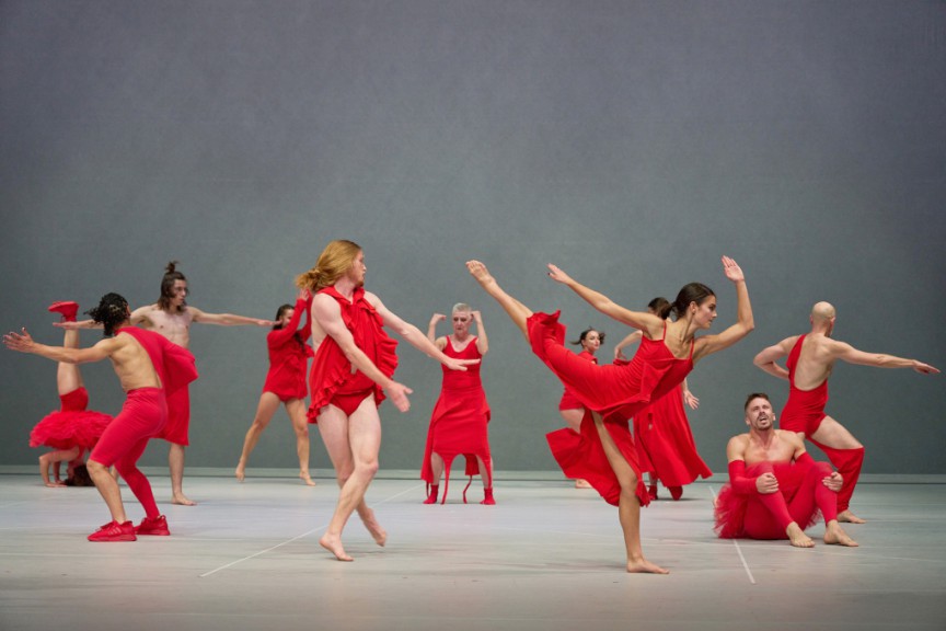 Dancers dressed in red, dancing in a circle
