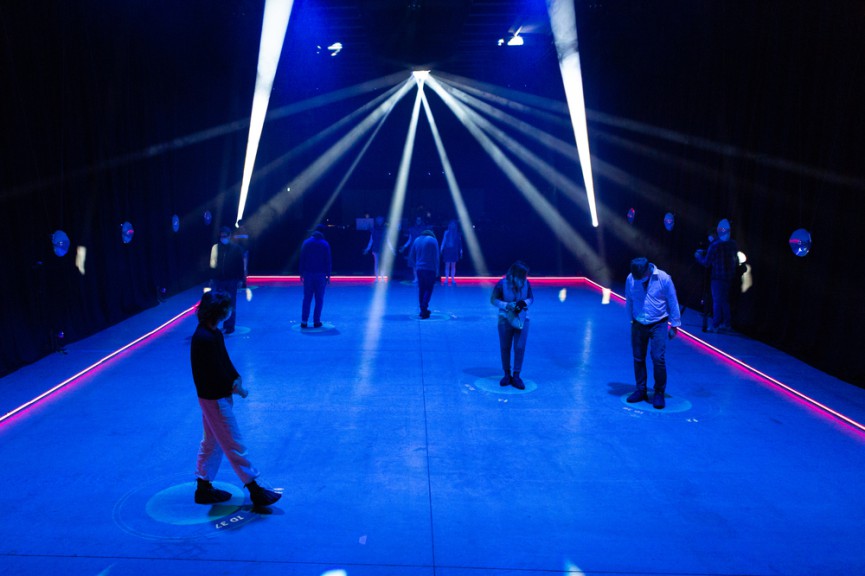 people standing on blue floor surface light by spotlights