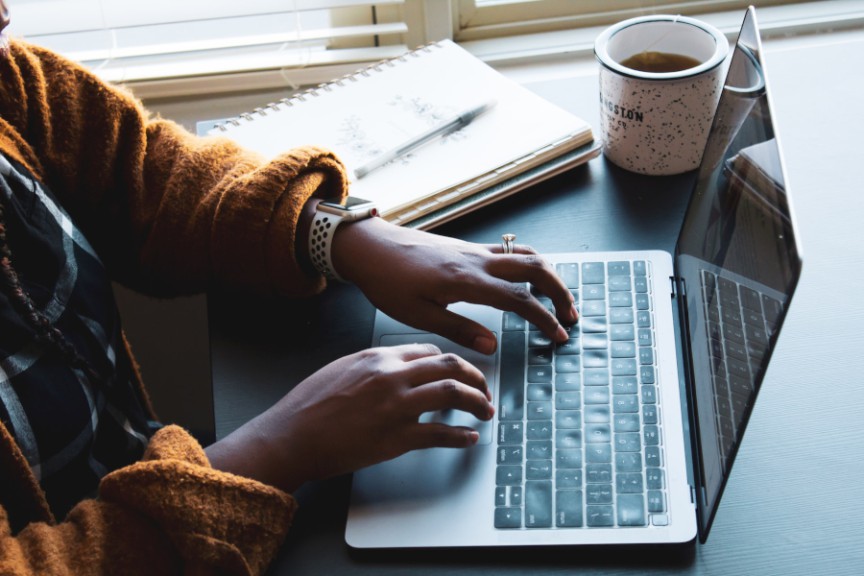 elevated view of woman's hands on laptop keyboard