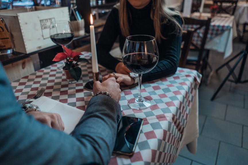 couple seated across the table at restaurant holding hands
