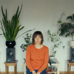 nadia parfan sits in front of her houseplants