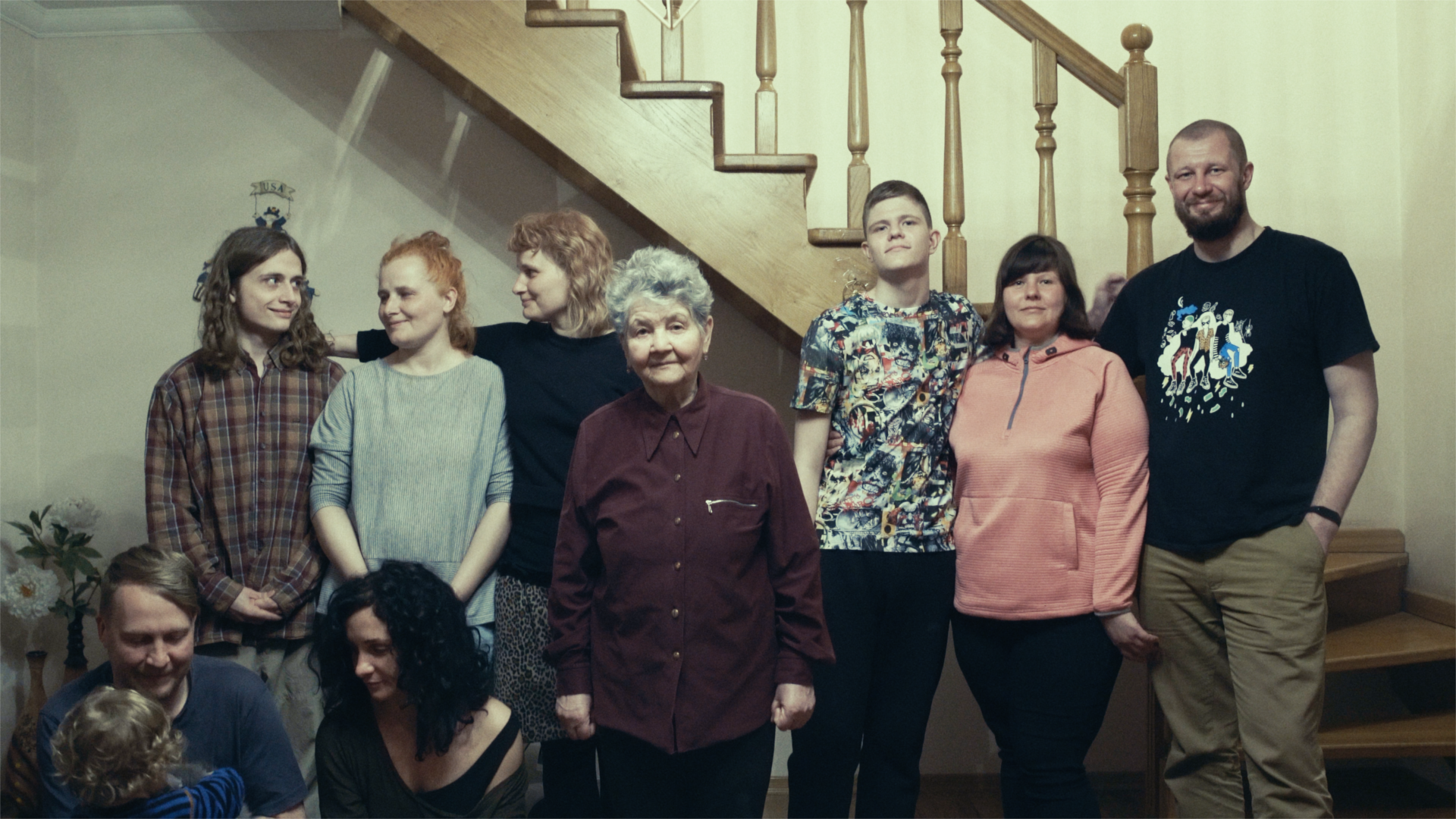family and friends stand in front of a staircase